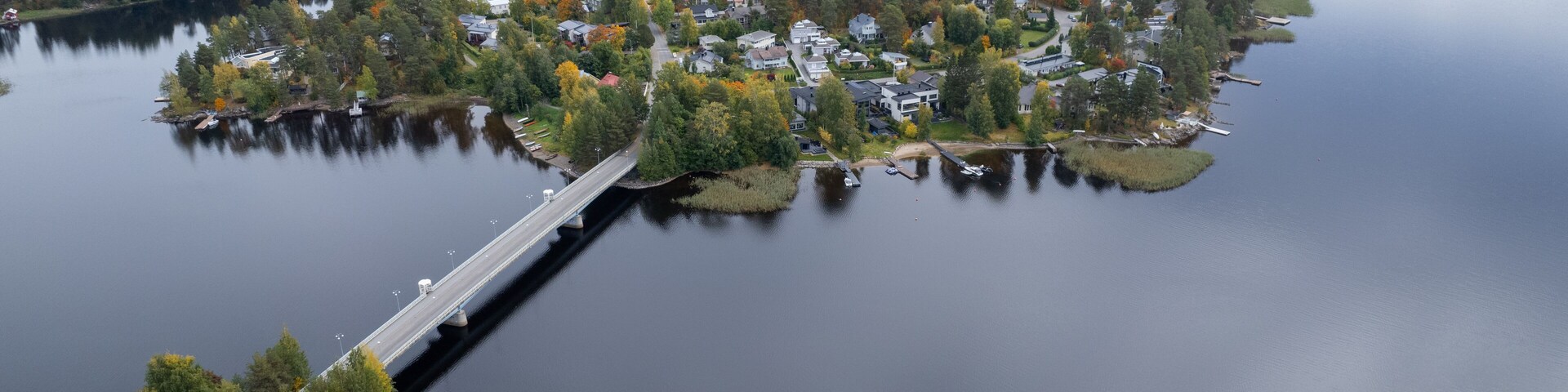 Vista aérea de un lago rodeado de islas boscosas con un puente que las conecta.
