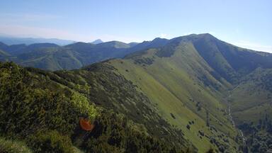 A mountainous landscape with rolling hills and a winding path.