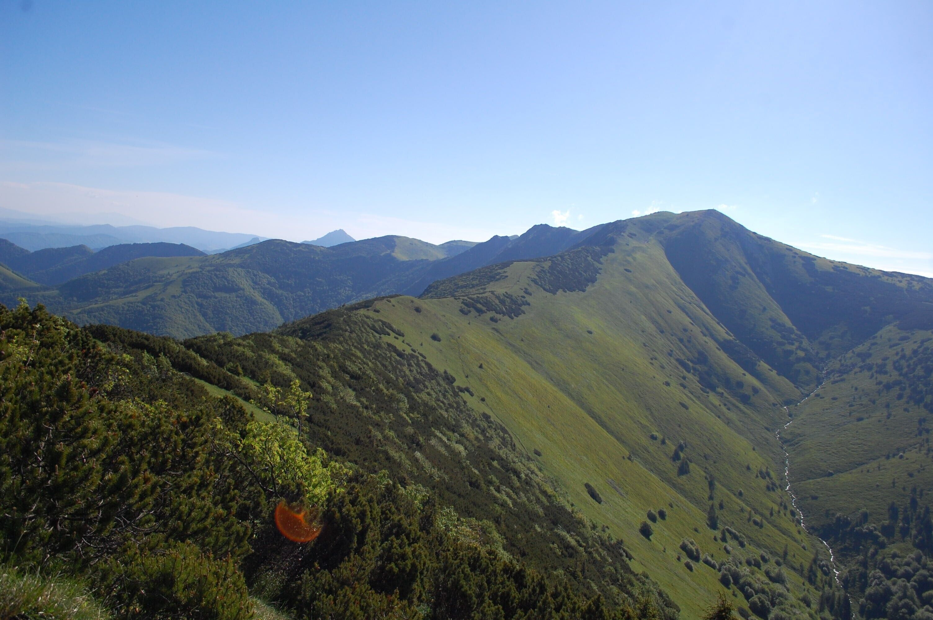 A mountainous landscape with rolling hills and a winding path.