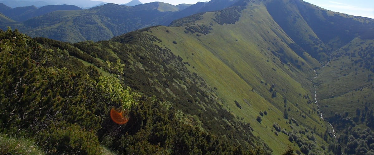A mountainous landscape with rolling hills and a winding path.