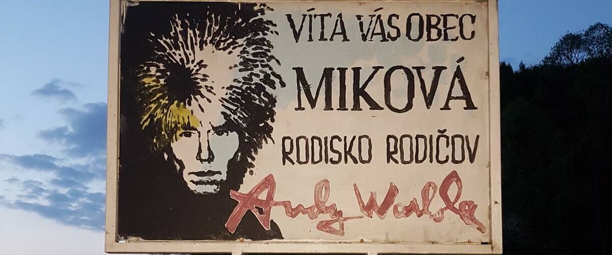 A sign with a portrait and text in a foreign language.