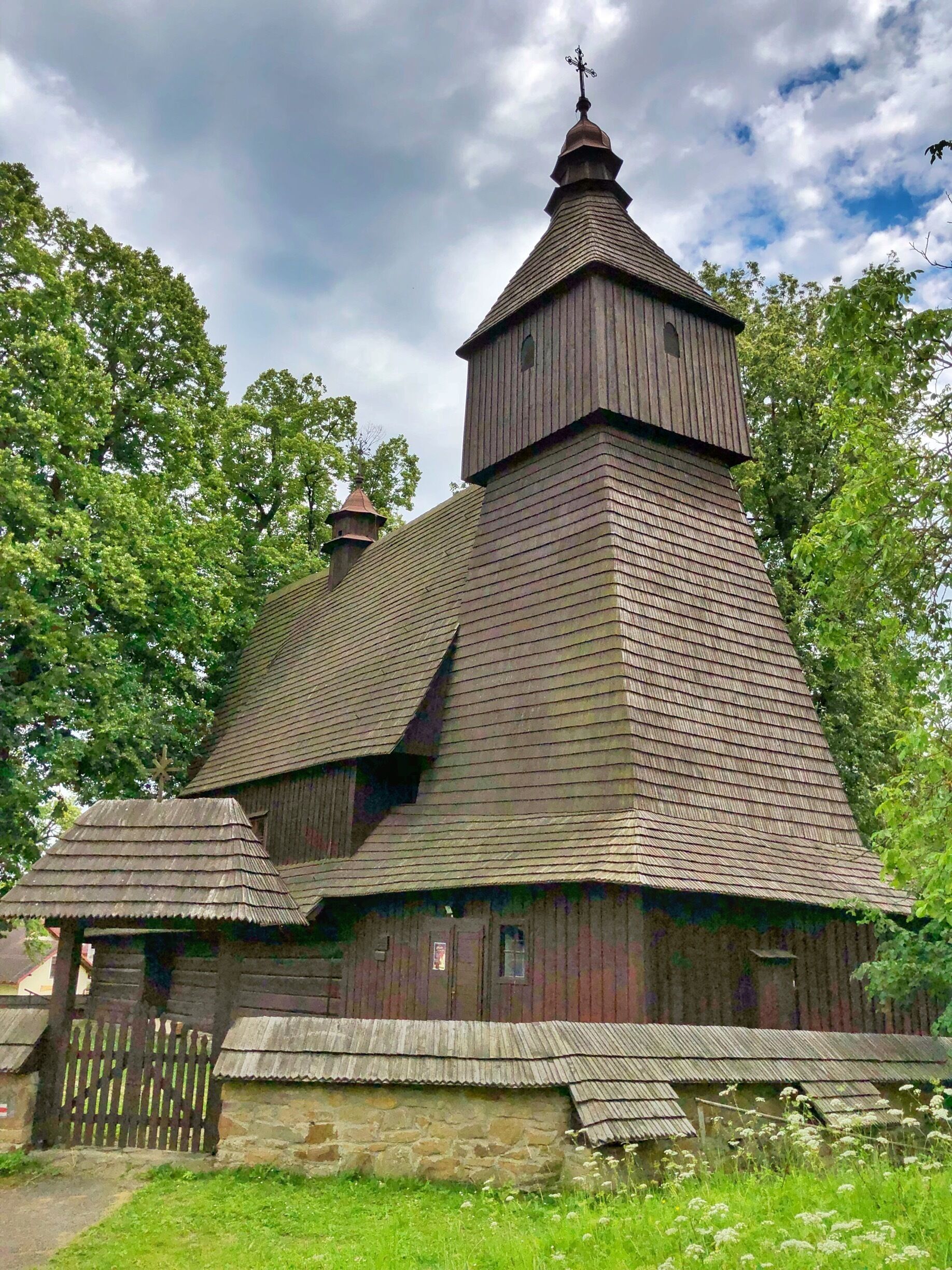 A wooden church with a steeply pitched roof and a bell tower.