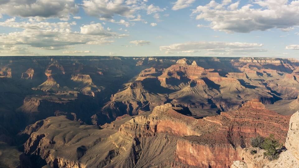 A vast canyon with layered rock formations and a clear sky.
