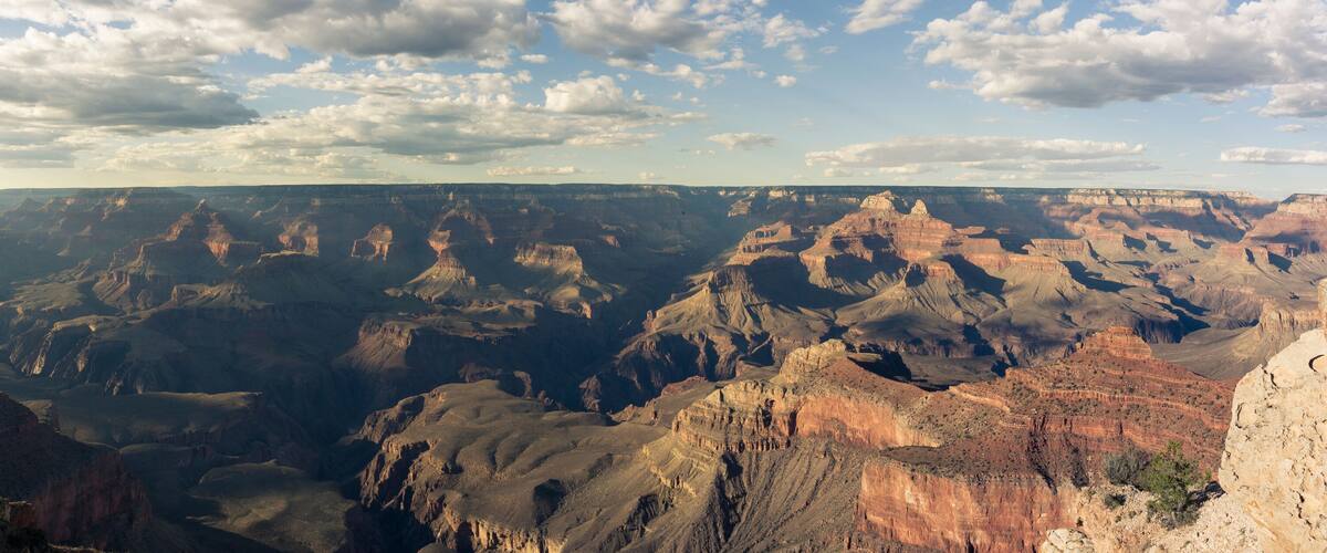 A vast canyon with layered rock formations and a clear sky.