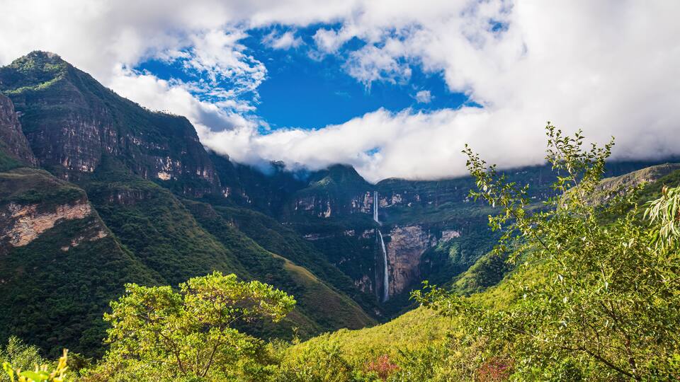 A mountainous landscape with lush greenery and waterfalls.