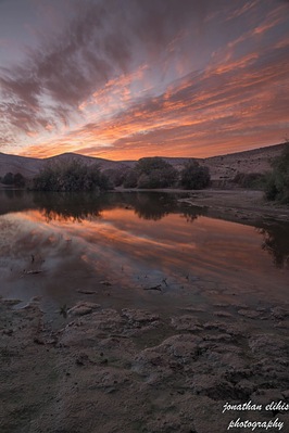 small lake at the desert wirh some kind of dirds