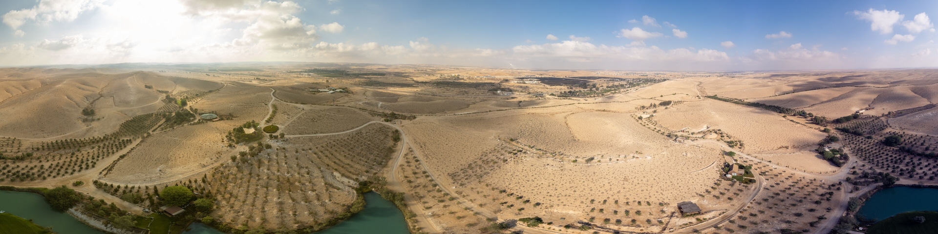 360 degrees panoramic view from the sky to Negev Desert with a small lake at morning
