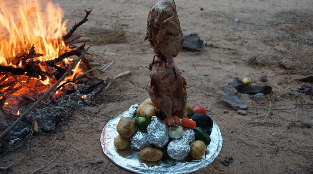 Dinner. An inverted 44 Gallon drum with a spike in the lid. All the vegetables at the bottom cook in the juices of the chicken. Since this is basically a massive dutch oven, the chicken is also super tender. Put the drum on top, seal it up then sit it in coals and put coals on top. Delicious!