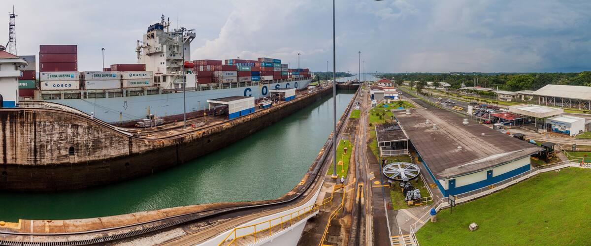 A large industrial port with a shipyard, cargo containers, and a lock system.