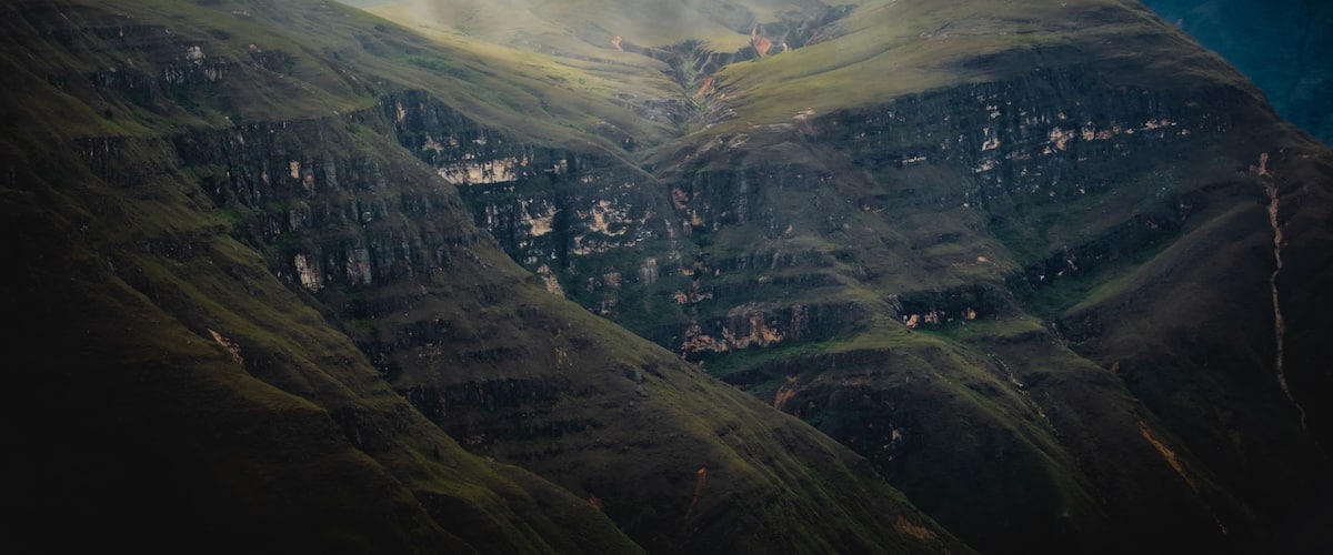 View of the dramatic cliffs and deep green slopes of the Mirador del Canon de Huancas Sonche under a moody, cloud-covered sky in Chachapoyas, Amazonas, Peru.