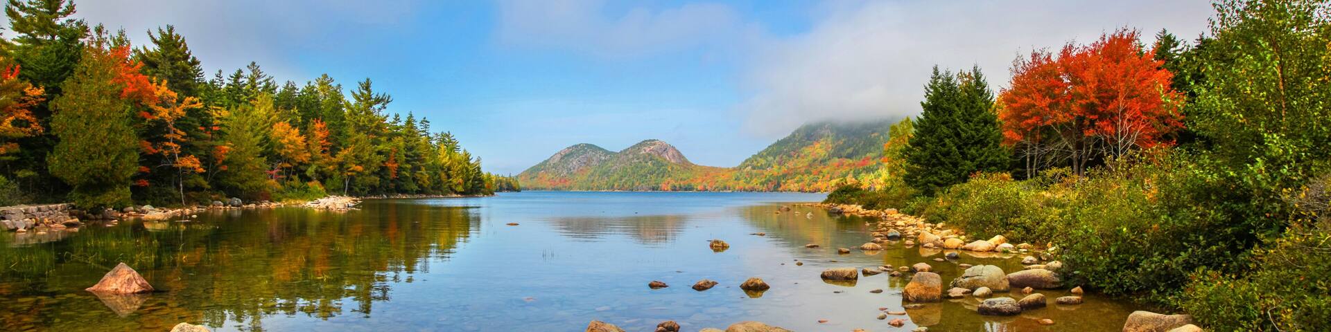 View of the clear water, stones and fall foliage of Jordan Pond in Acadia National Park
