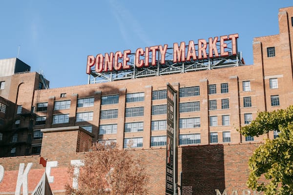 Bygningens ydre for Ponce City Market, med et stort skilt der siger "Ponce City Market" og et mindre skilt nedenunder, der reklamerer for "drinks, spisning, events".