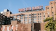 Fasaden på byggnaden som inrymmer Ponce City Market pryds av en stor skylt med texten "Ponce City Market" och en mindre skylt nedanför som annonserar "drycker, restauranger, evenemang".