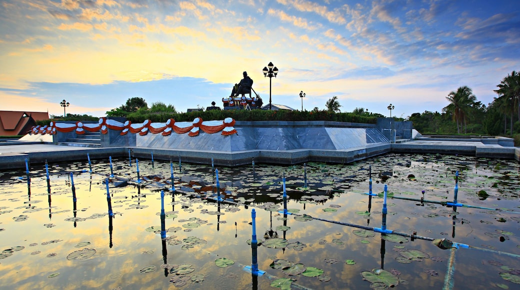 The monument depicts a bronze statue of King Mongkut in naval uniform, seated on a chair at Waghor King Mongkut Memorial Park of Science and Technology, Prachuap Khiri Khan province Thailand