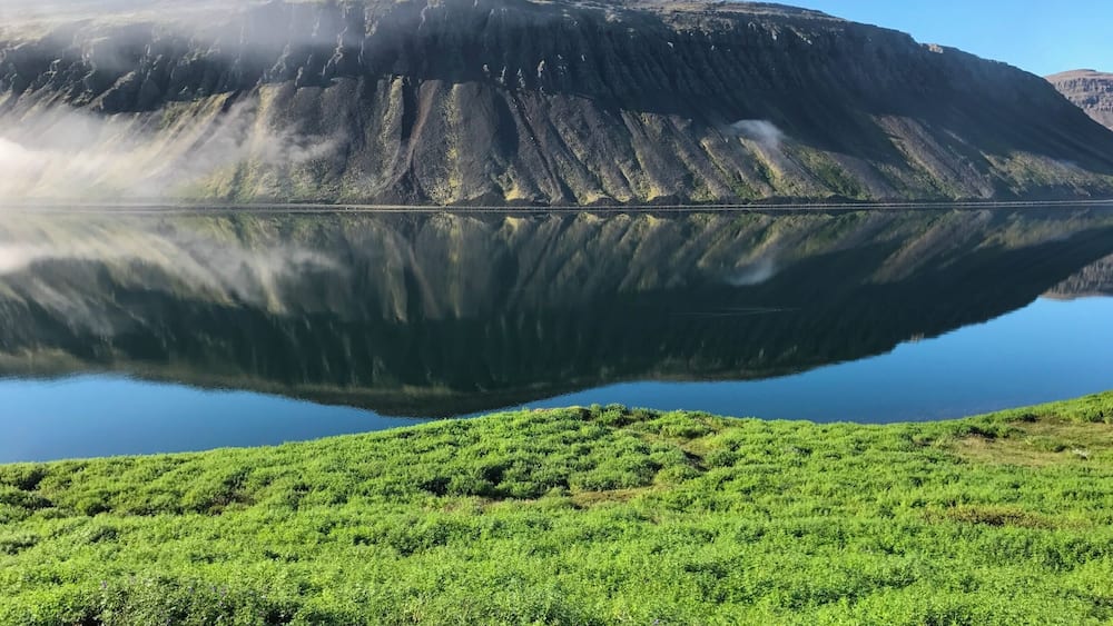 The Westfjords of Iceland is a large peninsula in northwestern Iceland. It has a mountainous coastline, heavily indented by dozens of fjords surrounded by steep hills. These fjords make roads circuitous and difficult to drive. The mountain scenery is rugged but specular.