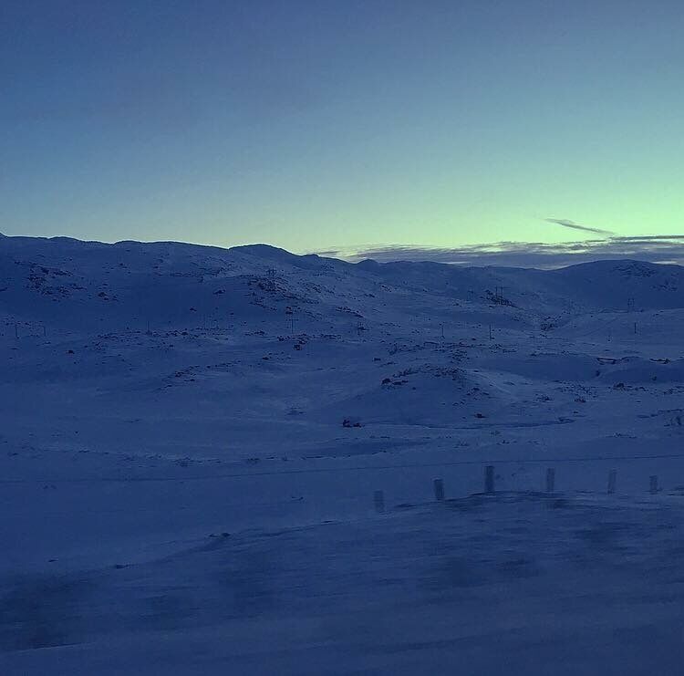 A snow-covered mountainous landscape with a clear sky.