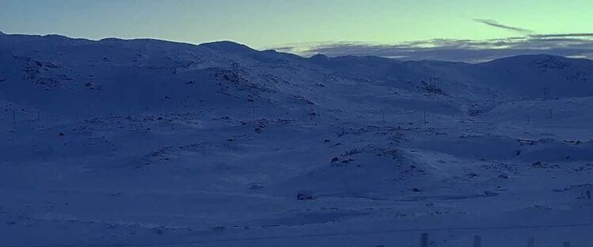 A snow-covered mountainous landscape with a clear sky.