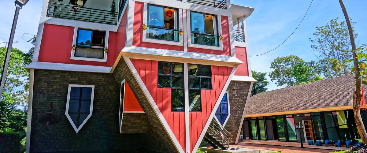 A modern multi-story building with a red and white color scheme, large windows, and a unique architectural design.