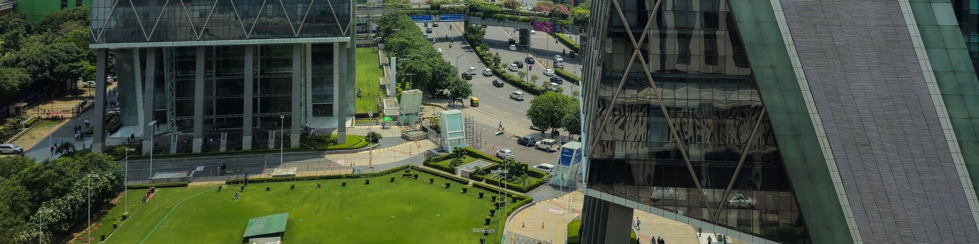 Gurgaon (Gurugram) National Capital Region (NCR), Haryana, India - June 6, 2023 : Unique view of Cyberhub buildings from upper floors in Cyber City with lawn and traffic road