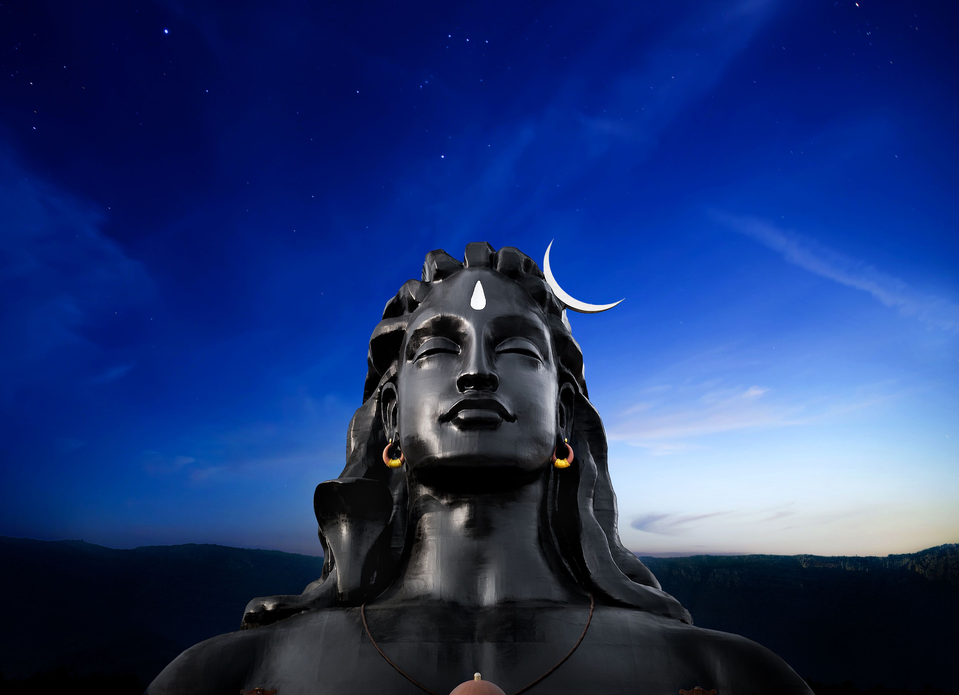 Estatua de una deidad con una luna creciente en la cabeza, sobre un cielo nocturno lleno de estrellas.