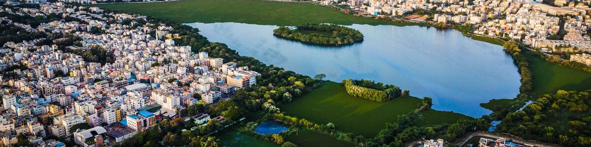 An aerial view of a city with a large lake surrounded by buildings and greenery.