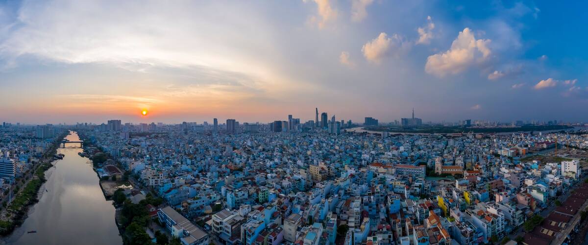 Sunset panorama of Ho Chi Minh City (Saigon) Vietnam from district 7 with canal and residential area in the foreground and city skyline in background