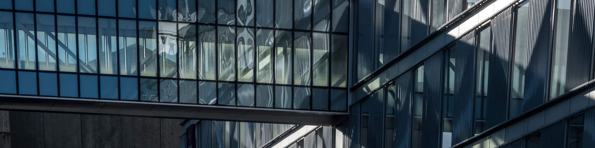 A modern building with large glass windows and a metal framework.