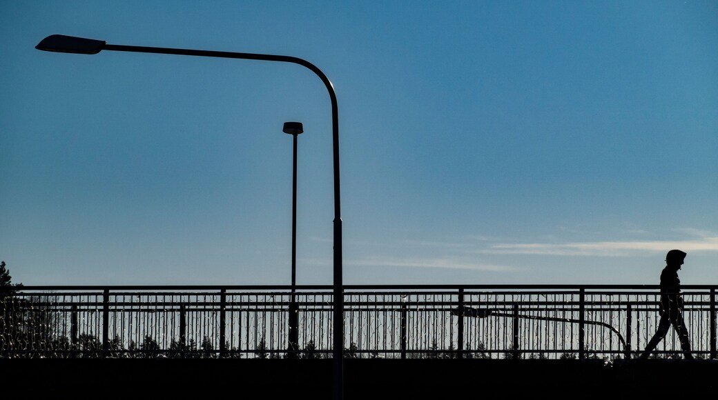 Stockholm, Sweden A man in silhouette in the Flemingsberg suburb or district on a sunny winter day walks on a bridge.