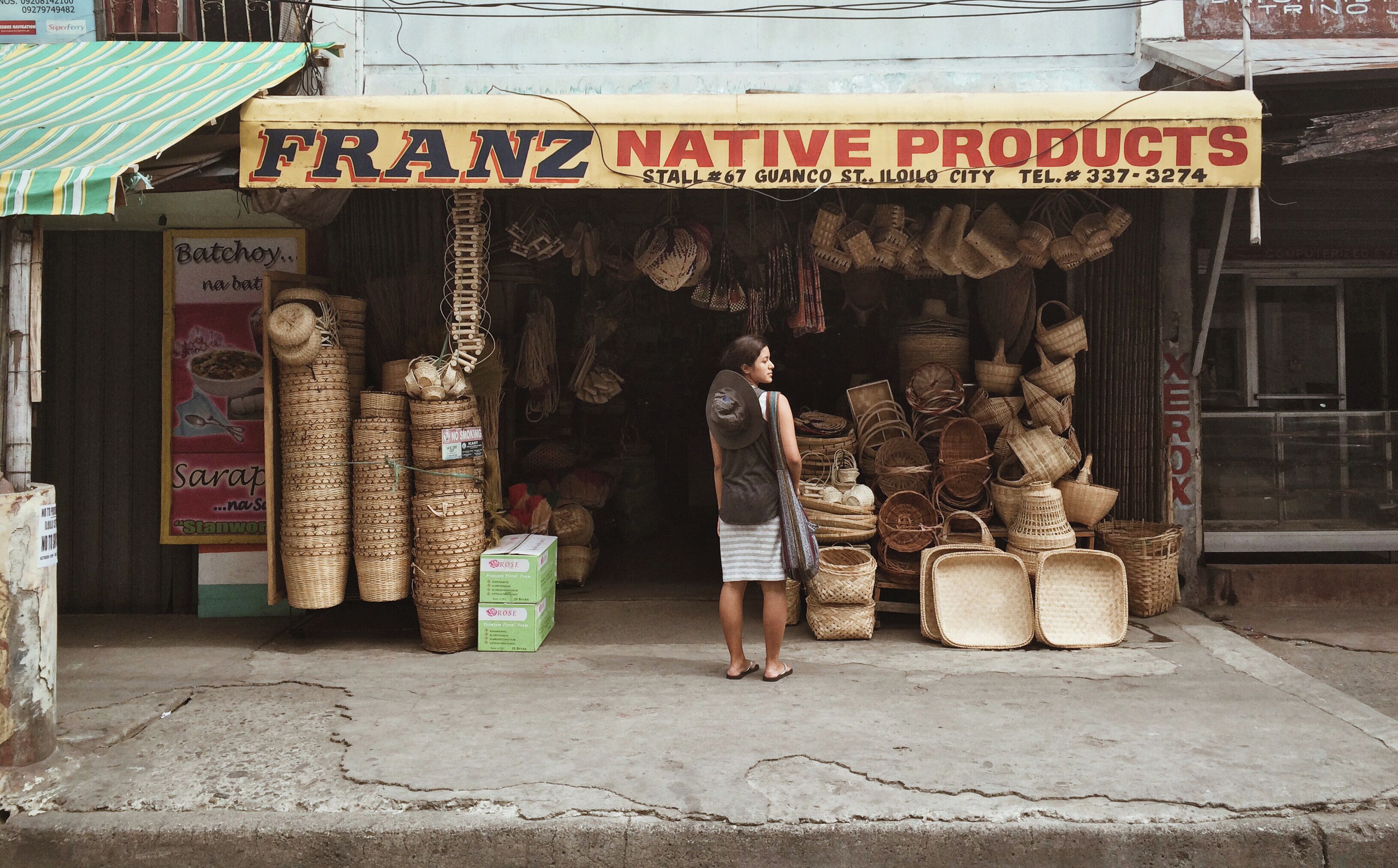 A storefront with a sign reading "FRANZ NATIVE PRODUCTS" and a variety of woven baskets and containers displayed outside.