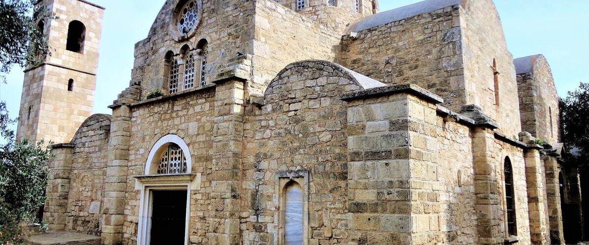 A historic stone church with a bell tower and arched windows.