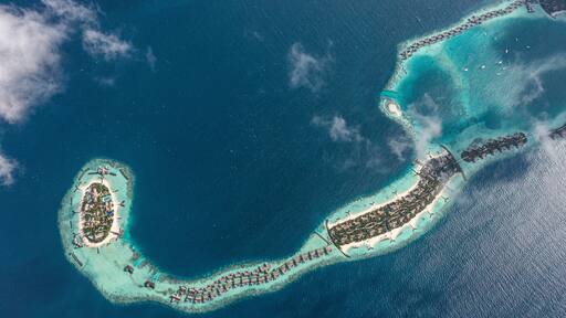 Aerial view of Ithaafushi Island with low clouds, Maldives archipelagos.