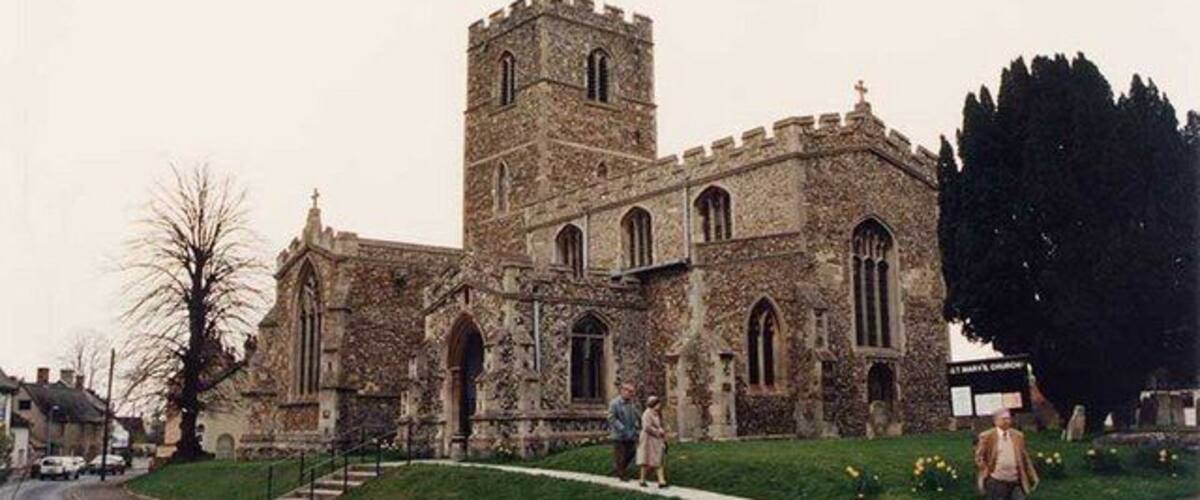 A historic stone church with a prominent tower and arched windows.