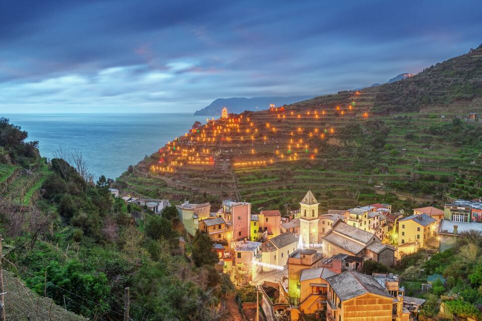 A coastal village with terraced fields and a prominent church.