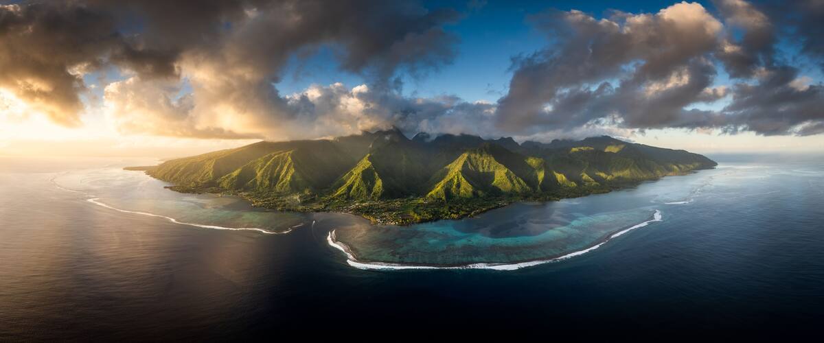 Une île tropicale aux montagnes verdoyantes et aux eaux d’un bleu cristallin.