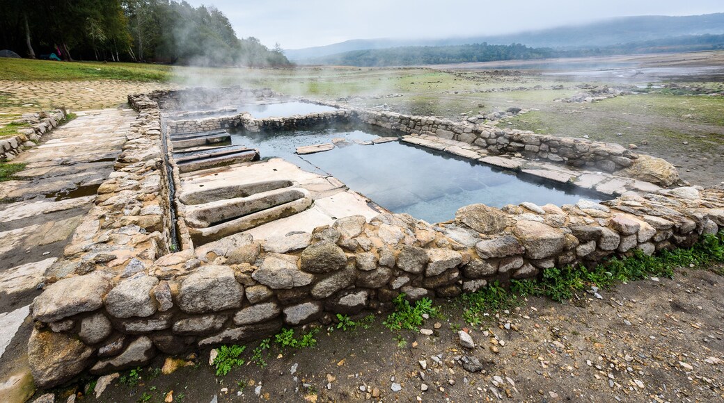 Natural Roman baths outdoors with hot steam and thermal water.