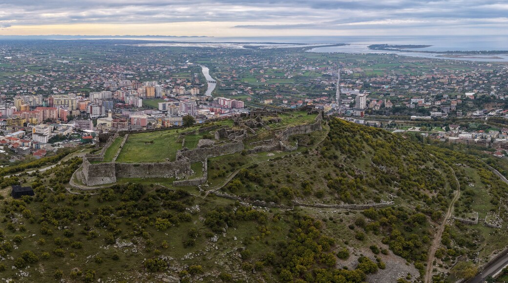 Aerial panorama of Lezhë Castle overlooking the town, Drin River and the Adriatic wetlands under soft cloudy evening light.