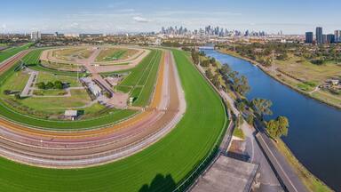 Panoramic aerial view of a wide bend on a horse racing track with a river running along side