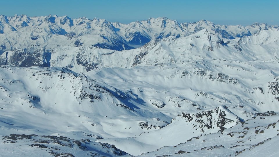 A snow-covered mountain range with rugged peaks and valleys.
