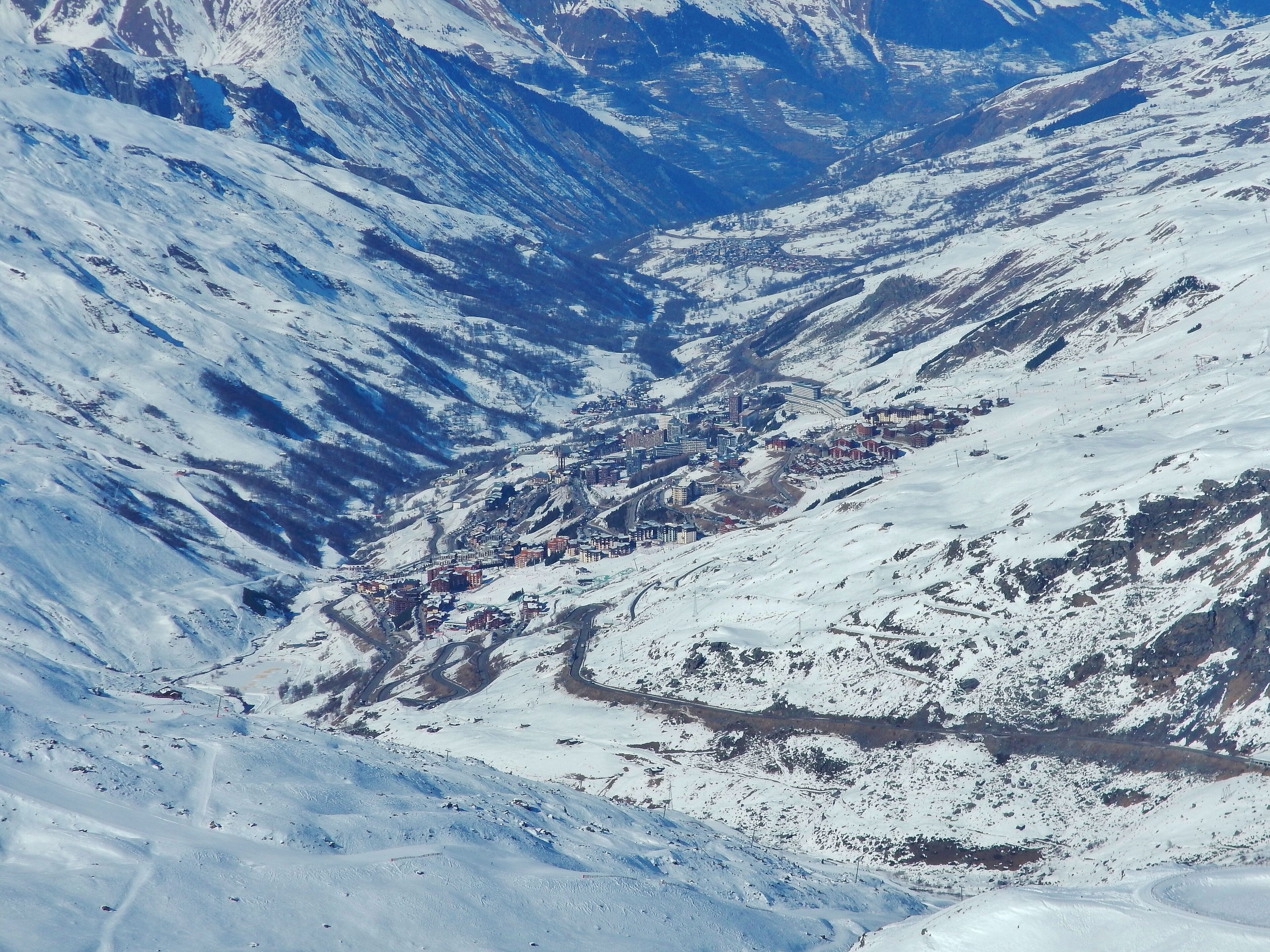 A snow-covered mountainous landscape with a town nestled in a valley.