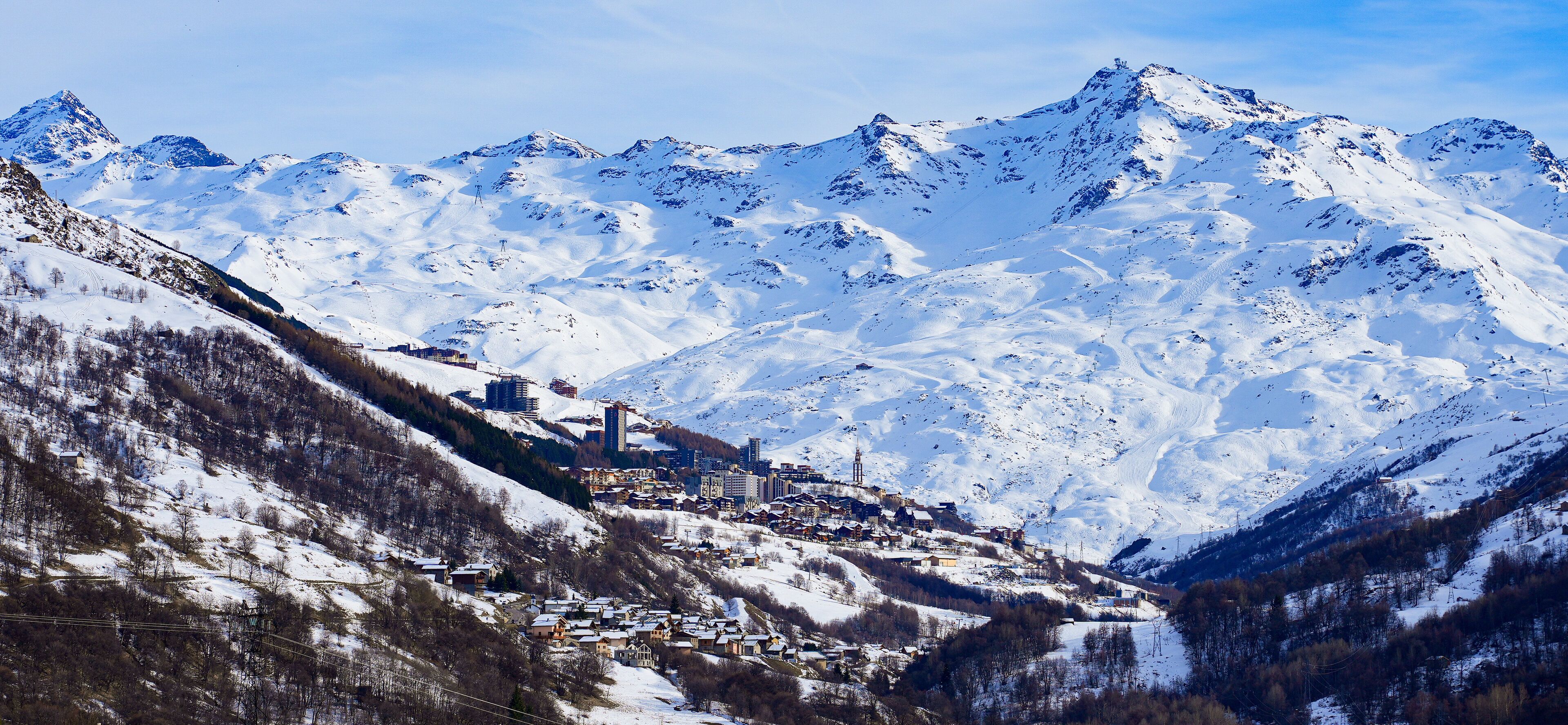 A snow-covered mountain range with a town nestled at the base.