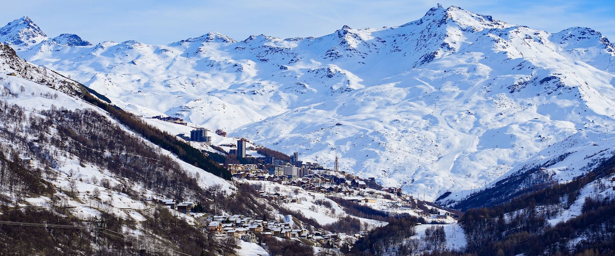 A snow-covered mountain range with a town nestled at the base.