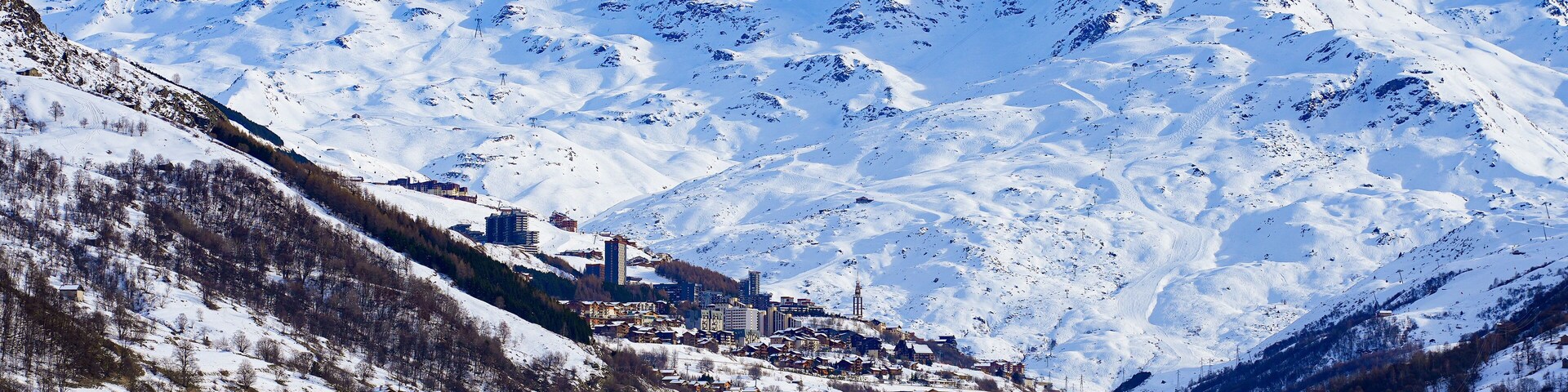 A snow-covered mountain range with a town nestled at the base.