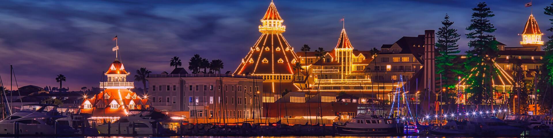 Historic hotel decorated with holiday lights during Christmas with reflections in the water
