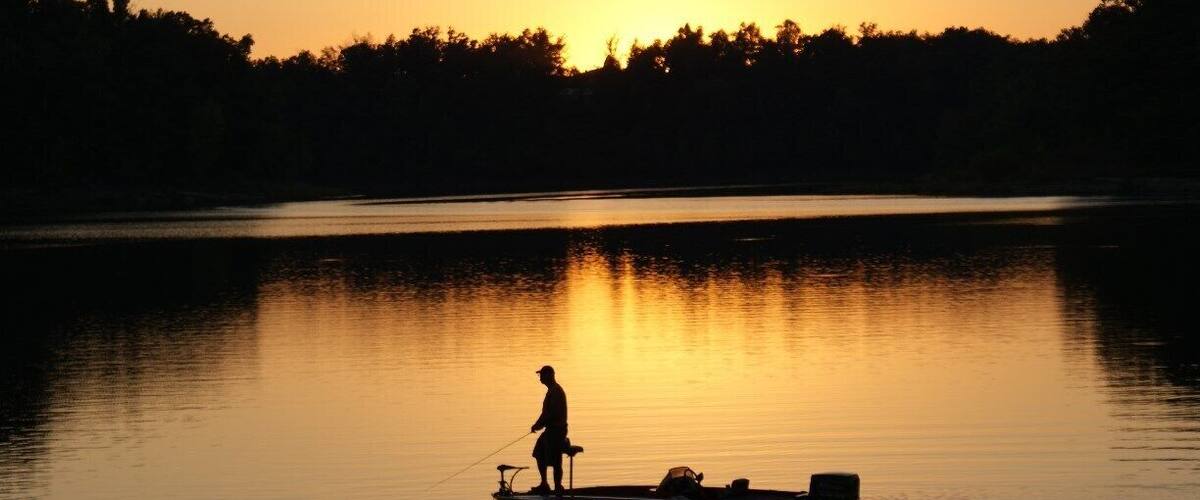 Lone fisherman at dusk on beautiful Nolin Lake.
