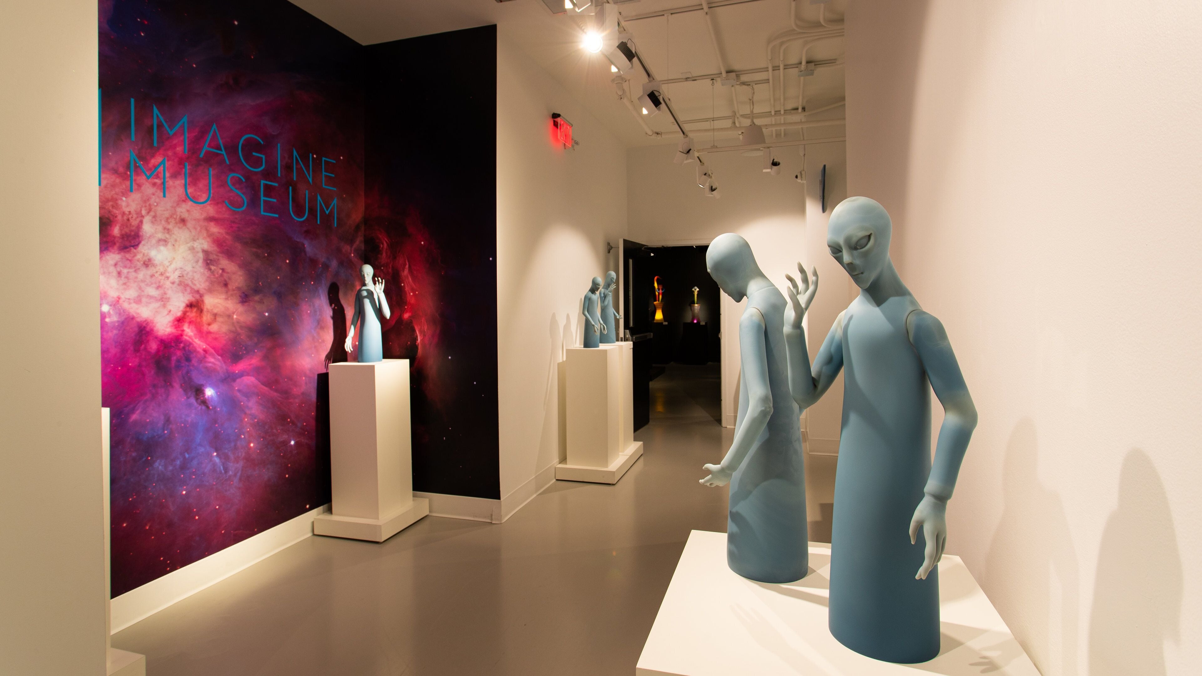 A modern art gallery with abstract sculptures and a cosmic-themed backdrop.