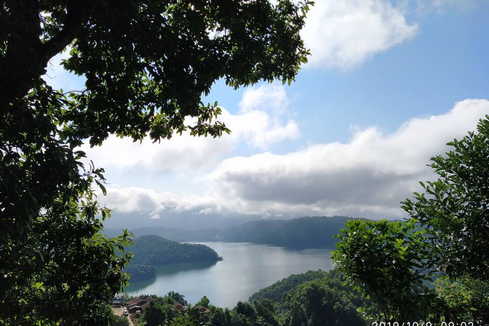 Un lac entouré d’une végétation luxuriante et de collines.