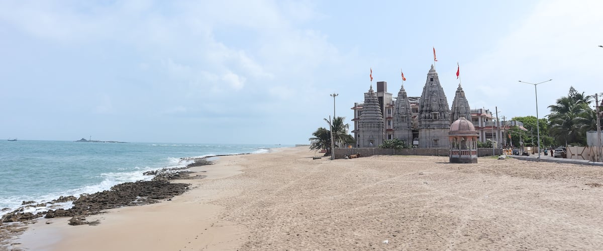 A beach with a temple and ocean.