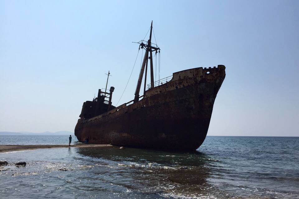 Un gran naufragio oxidado varado en la playa.