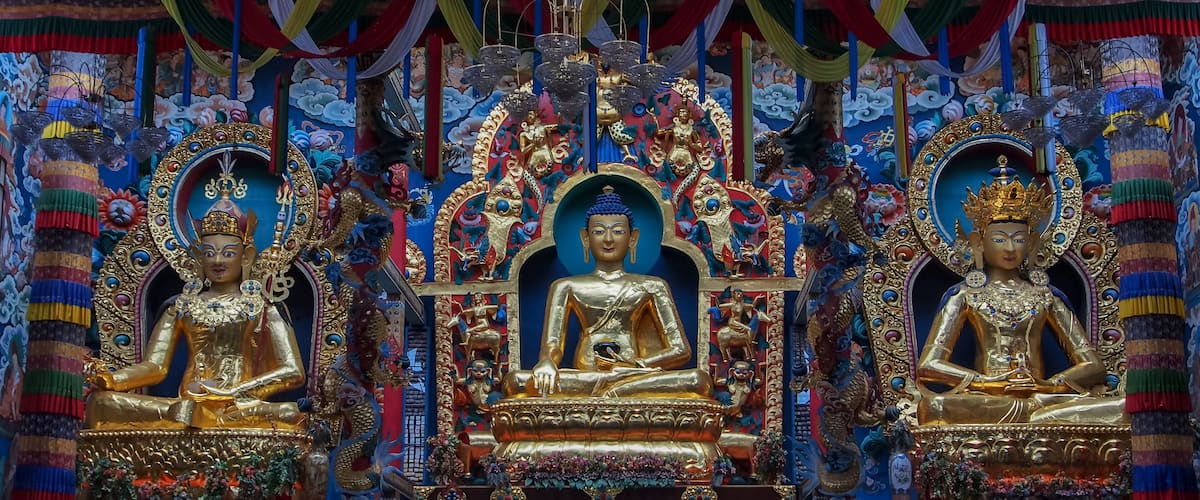 A golden Buddha statue surrounded by colorful decorations and intricate designs.