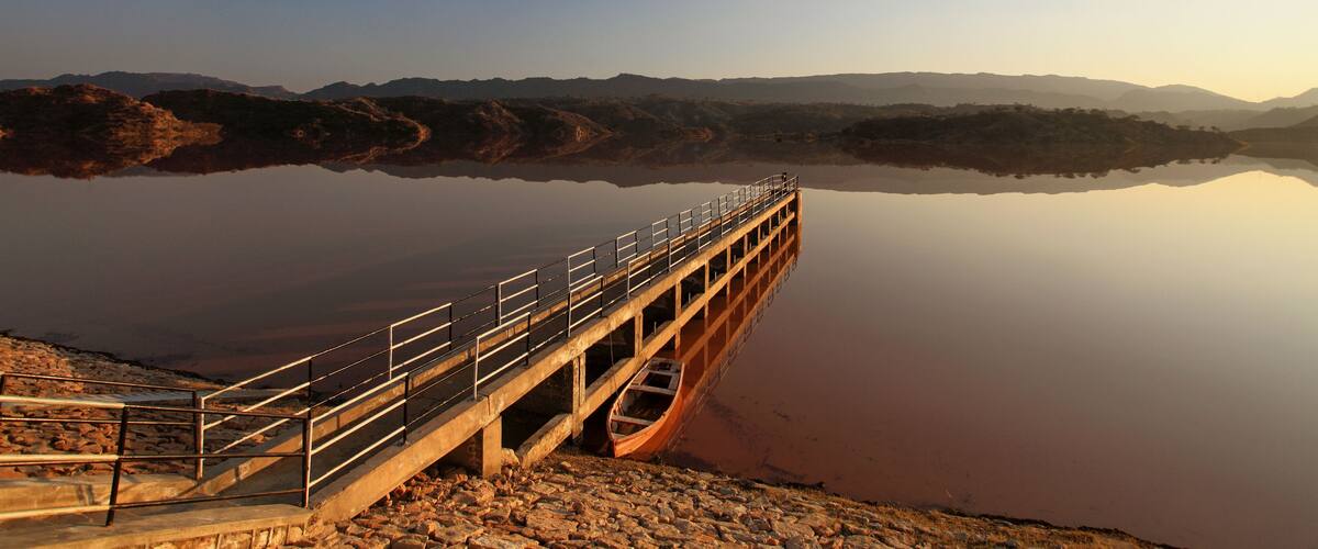 A bridge over a calm river with a clear sky.
